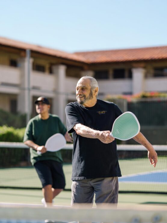Active seniors enjoy friendly matches on the tennis court, fostering community and joy.