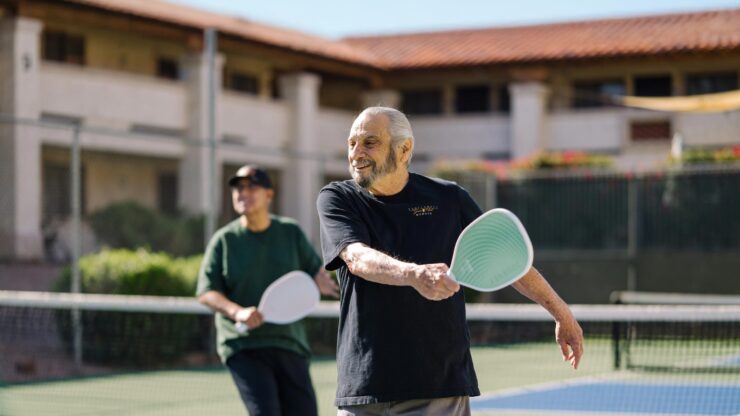 Active seniors enjoy friendly matches on the tennis court, fostering community and joy.