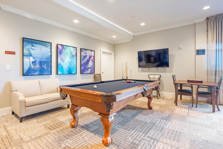 A welcoming game room featuring a billiards table, inviting seating, and vibrant artwork for community fun.