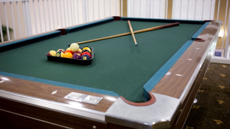 A cozy pool table awaits friendly games, fostering community and connection in a warm atmosphere.
