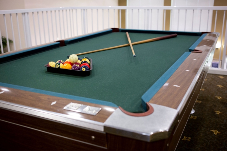 A cozy pool table awaits friendly games, fostering community and connection in a warm atmosphere.