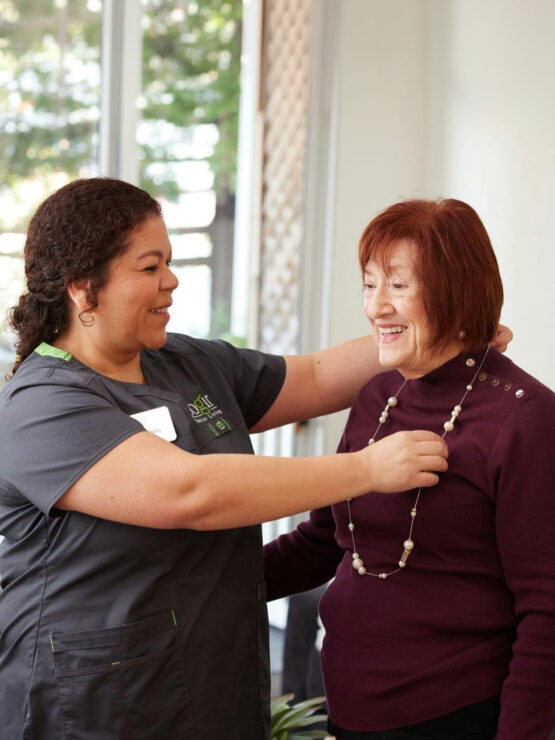 A warm interaction between caregivers and residents fosters a sense of community and belonging.