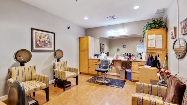 A cozy salon space with warm colors, inviting seating, and a friendly atmosphere for community pampering.