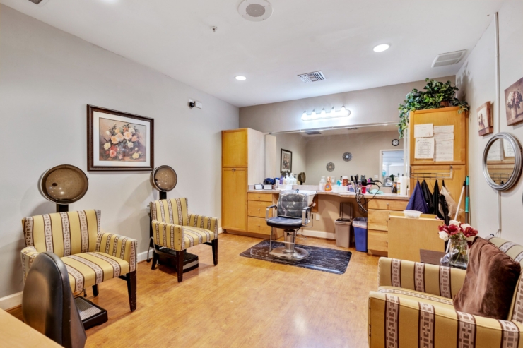 A cozy salon space with warm colors, inviting seating, and a friendly atmosphere for community pampering.