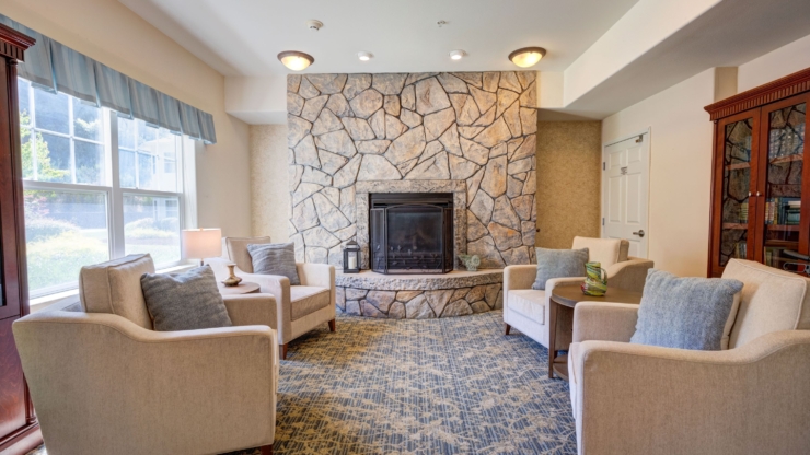 Cozy seating surrounds a warm fireplace, inviting residents to relax and connect in comfort.