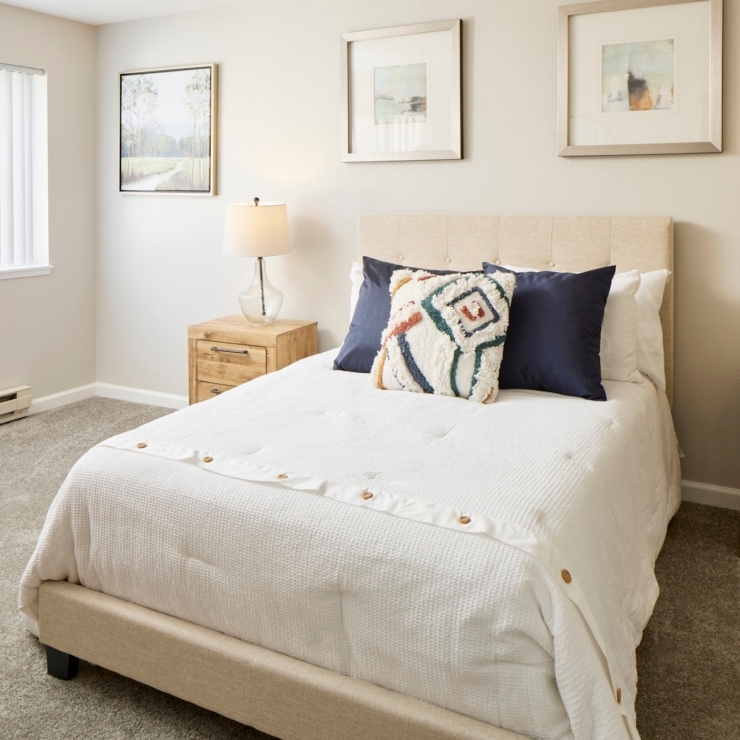 A bright, inviting bedroom with soft furnishings and warm decor, perfect for relaxation and community.