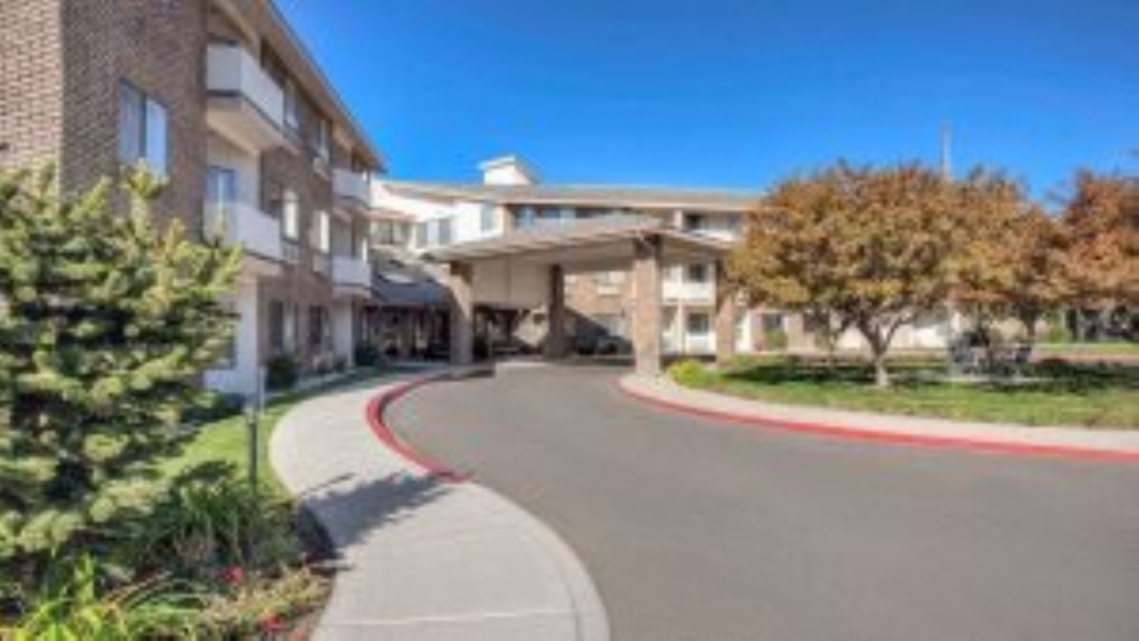 A welcoming entrance with lush greenery, inviting residents to a vibrant community filled with care.