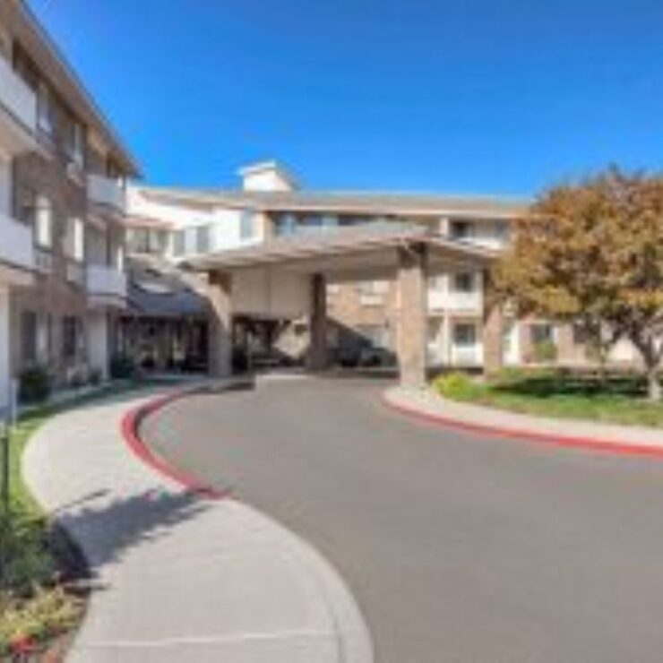 A welcoming entrance with lush greenery, inviting residents to a vibrant community filled with care.