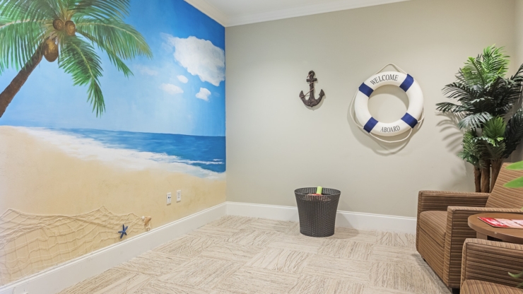 A vibrant beach mural sets a welcoming tone, inviting residents to relax and connect in this cheerful space.