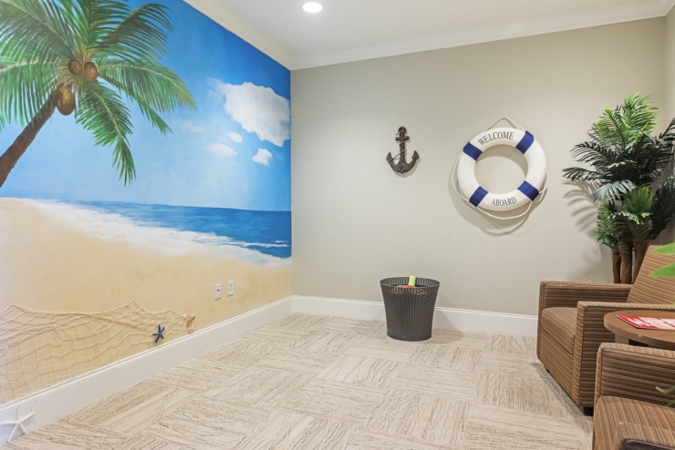 A vibrant beach mural sets a welcoming tone, inviting residents to relax and connect in this cheerful space.