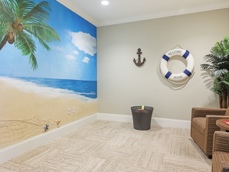 A vibrant beach mural sets a welcoming tone, inviting residents to relax and connect in this cheerful space.