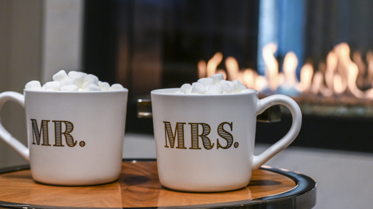 Warm mugs filled with marshmallows sit by a cozy fireplace, inviting moments of togetherness.