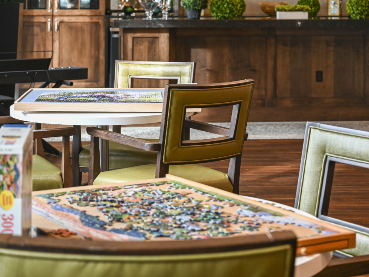A warm and inviting space with puzzle tables, fostering community and connection among residents.