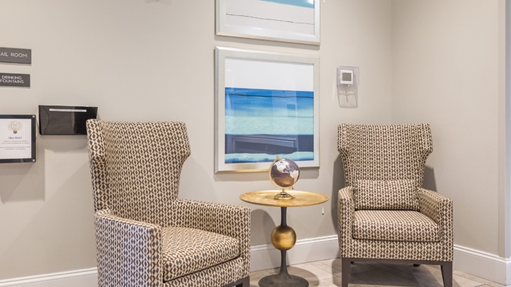 A welcoming lounge features stylish armchairs and calming artwork, perfect for community gatherings.