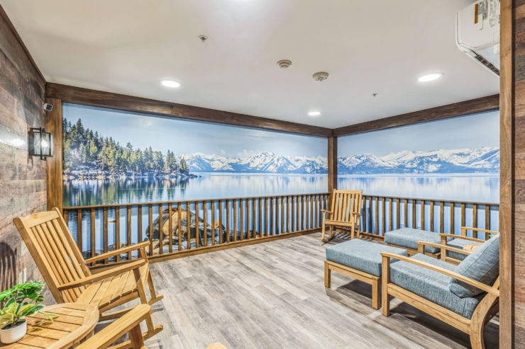 Relaxing space with inviting wooden seating, framed by serene lake and mountain views.