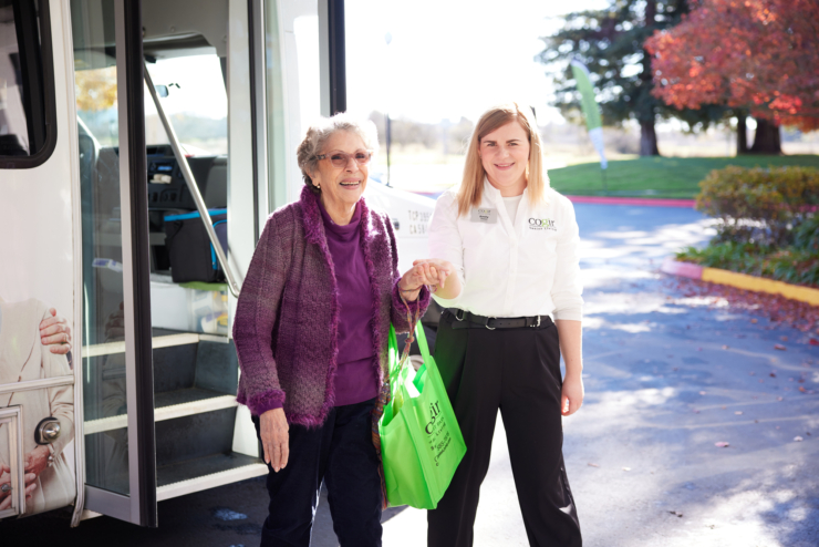 A joyful moment as a resident receives a warm welcome and support from staff, embodying community spirit.