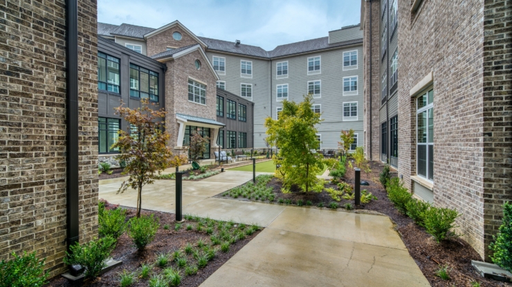 A serene courtyard invites connection and relaxation, surrounded by beautiful greenery and welcoming spaces.