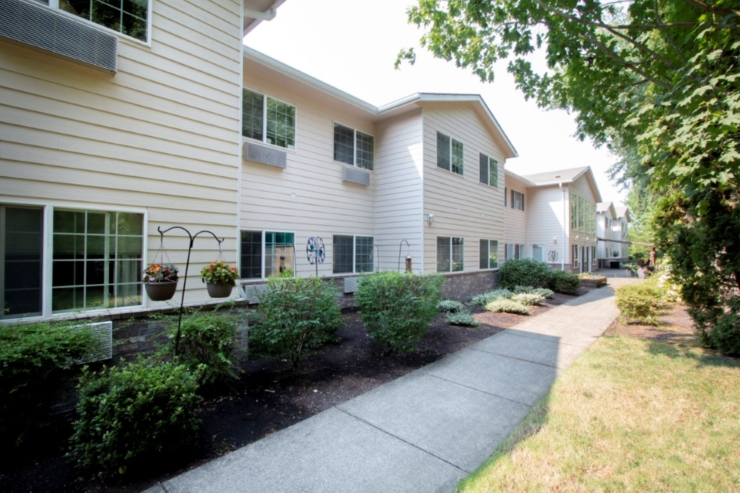 A welcoming pathway lined with greenery leads to bright, inviting residences, fostering community warmth.