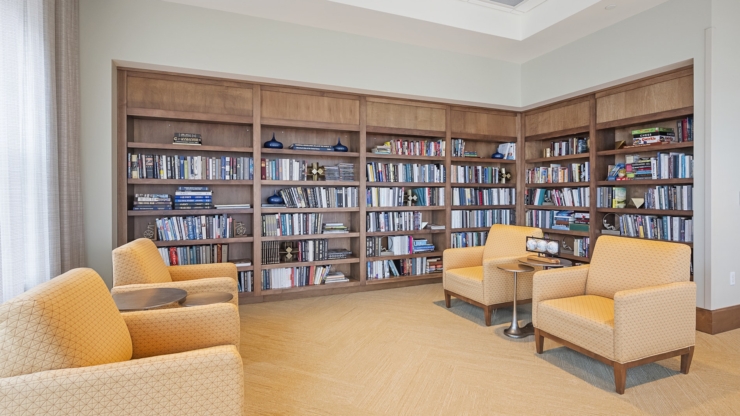 A cozy reading nook with warm colors, inviting chairs, and shelves filled with books, fostering community and comfort.