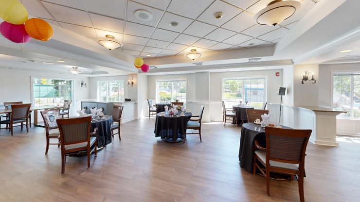 A bright dining area with inviting tables, cheerful decorations, and large windows fostering community warmth.