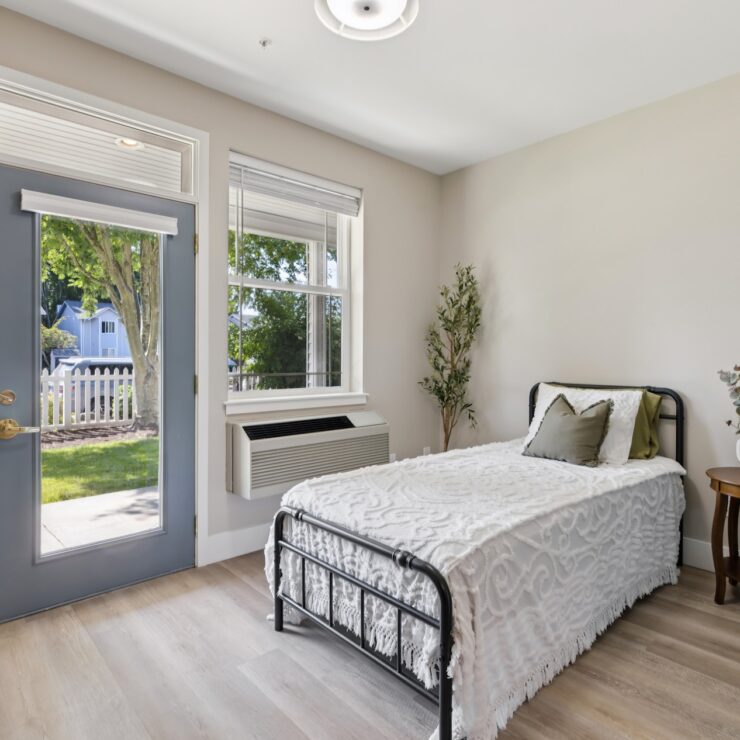 Bright and inviting space featuring a comfortable bed, welcoming decor, and a view of nature outside.