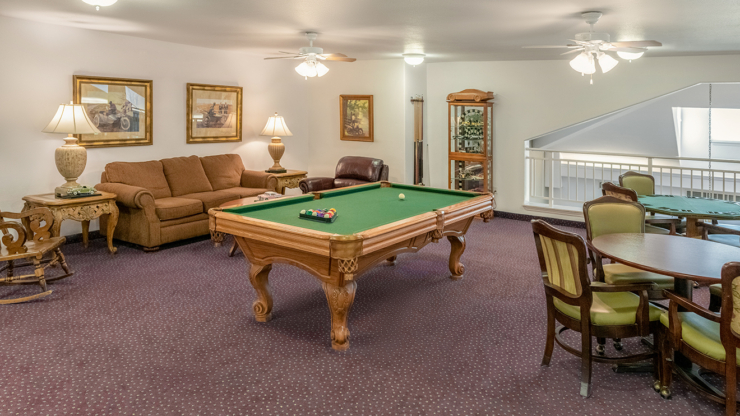 A welcoming lounge featuring a billiards table, cozy seating, and inviting decor, perfect for community gatherings.