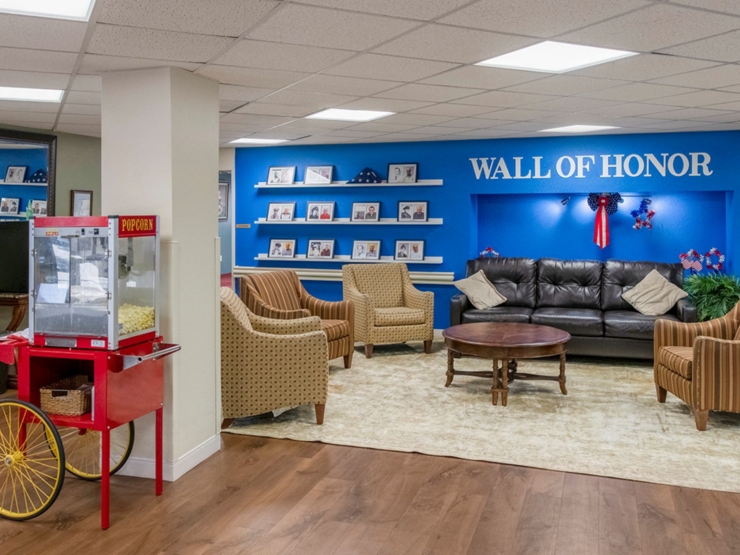 A welcoming lounge with cozy seating, a popcorn cart, and a vibrant Wall of Honor, fostering community and warmth.