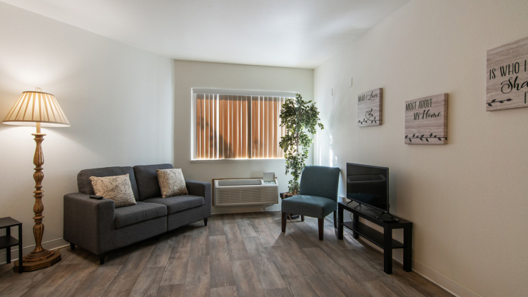 A cozy, inviting living space with warm lighting, comfortable seating, and personal touches for community warmth.