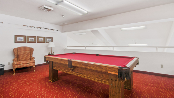 A vibrant game room featuring a pool table and inviting seating, perfect for socializing and fun.