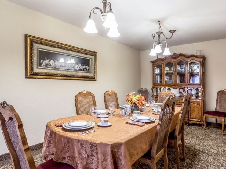 A warm dining area, inviting for community gatherings, features elegant decor and a cozy atmosphere.