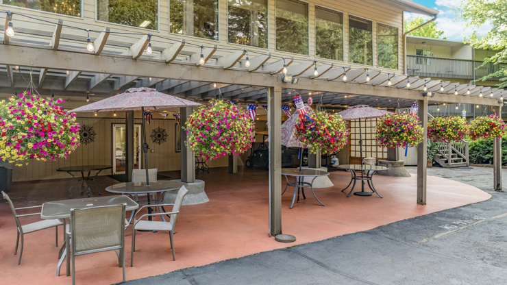 A vibrant outdoor space adorned with colorful flowers and umbrellas, inviting warmth and community.