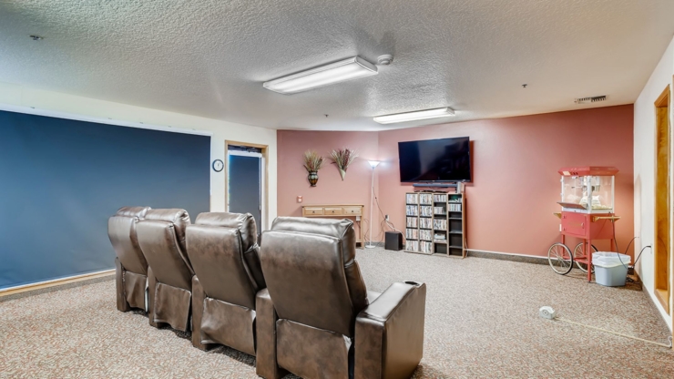 A cozy lounge with plush seating, inviting warmth, and a lively popcorn machine, perfect for gatherings.