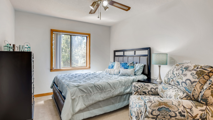 Bright and inviting room, featuring a comfortable bed and cozy seating, perfect for relaxation and community.