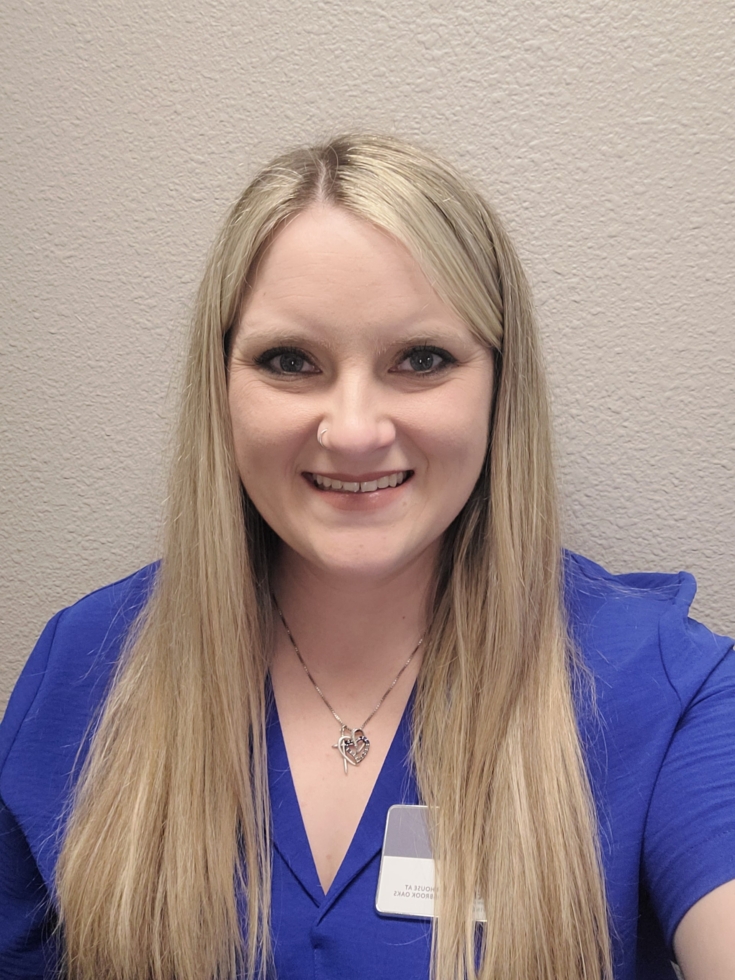 A friendly staff member radiates warmth and dedication, ready to welcome residents into a caring community.