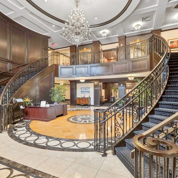 Elegant entryway with a grand staircase, inviting warmth and a sense of community.