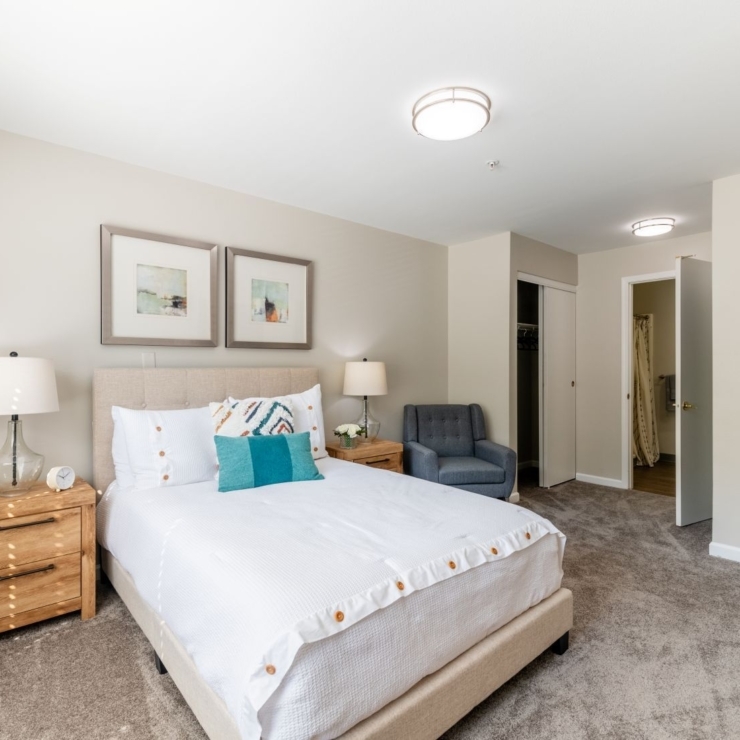 A cozy, well-lit room featuring a comfortable bed and inviting seating, perfect for relaxation.