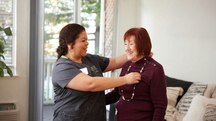 A warm interaction between a caregiver and resident highlights community spirit and joyful moments.