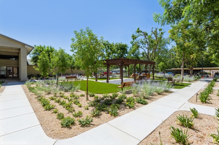 A serene garden with lush greenery, inviting seating, and a cozy gazebo, fostering community and comfort.