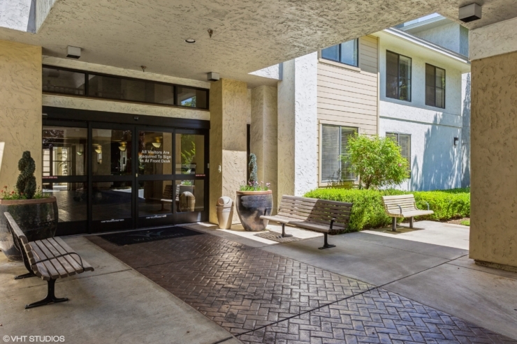 Welcoming entrance with inviting benches, lush greenery, and a bright, friendly atmosphere.