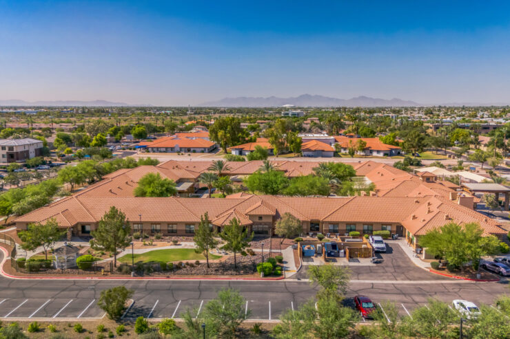 A welcoming retirement community surrounded by lush greenery and vibrant homes, fostering connection and comfort.