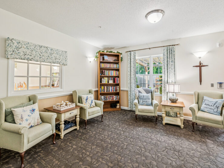 A bright, inviting space with comfortable seating, a bookshelf, and natural light, perfect for community gatherings.
