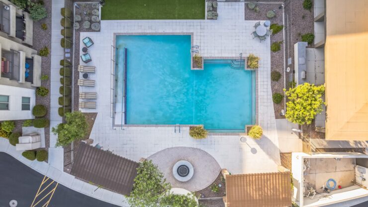 A serene pool area invites relaxation, surrounded by lush greenery and comfortable seating for gatherings.