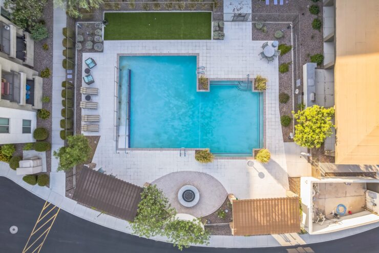 A serene pool area invites relaxation, surrounded by lush greenery and comfortable seating for gatherings.