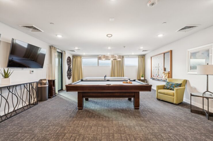 A welcoming game room with a pool table, inviting seating, and natural light, fostering community and comfort.