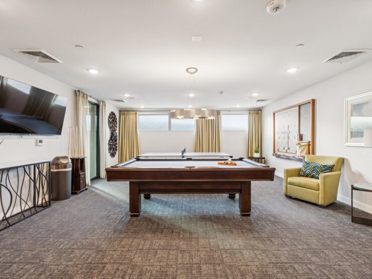 A welcoming game room with a pool table, inviting seating, and natural light, fostering community and comfort.