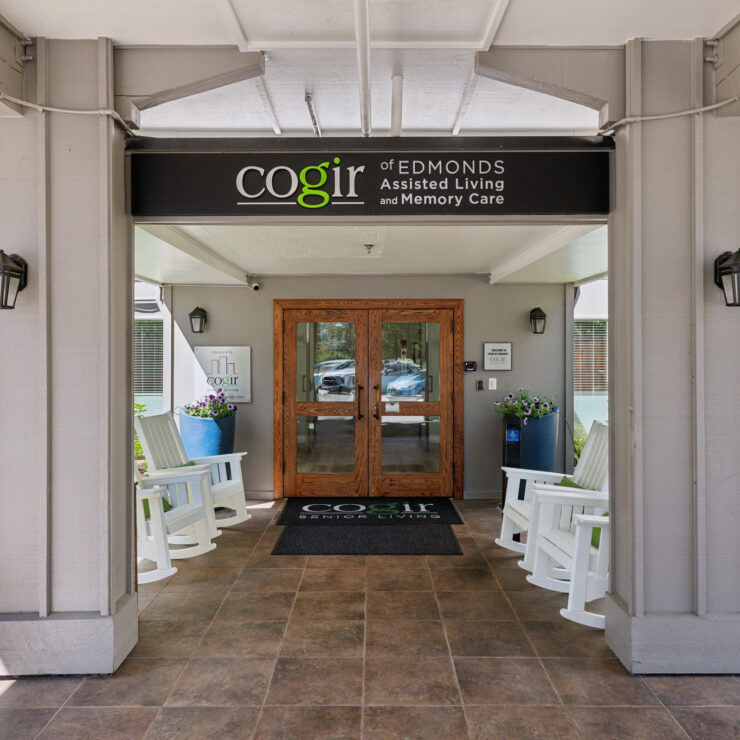 Welcoming entrance with bright seating, lush greenery, and a friendly atmosphere for community living.