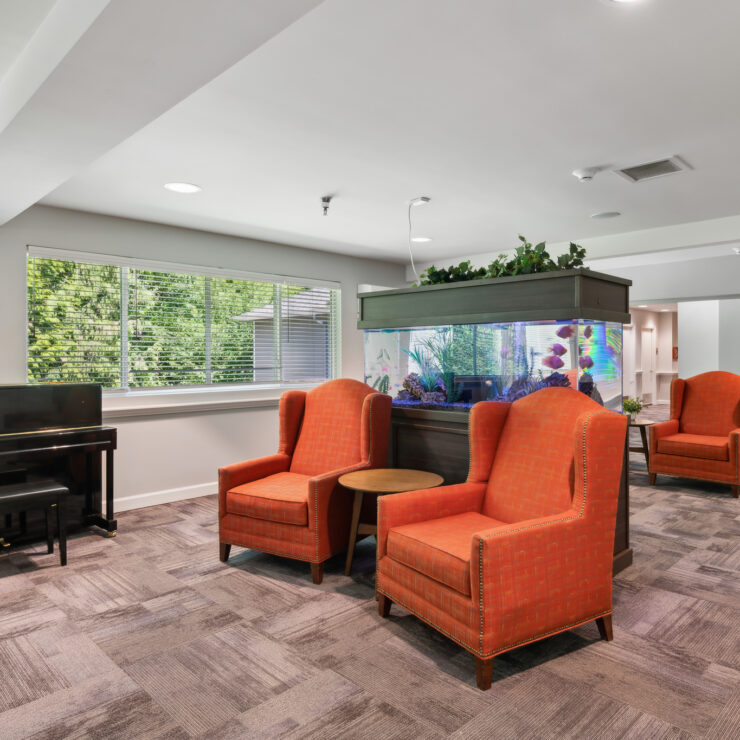 A welcoming space with vibrant seating, an aquarium, and natural light, perfect for community gatherings.