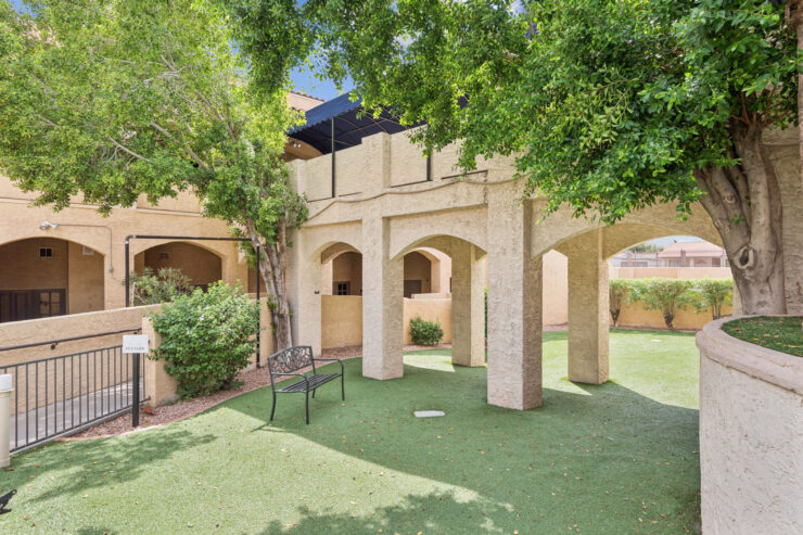 A welcoming outdoor space with lush greenery and shaded seating, perfect for community gatherings.