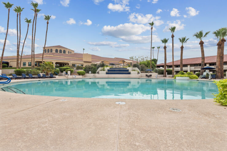 A serene pool area surrounded by lush palm trees, inviting relaxation and community gatherings.