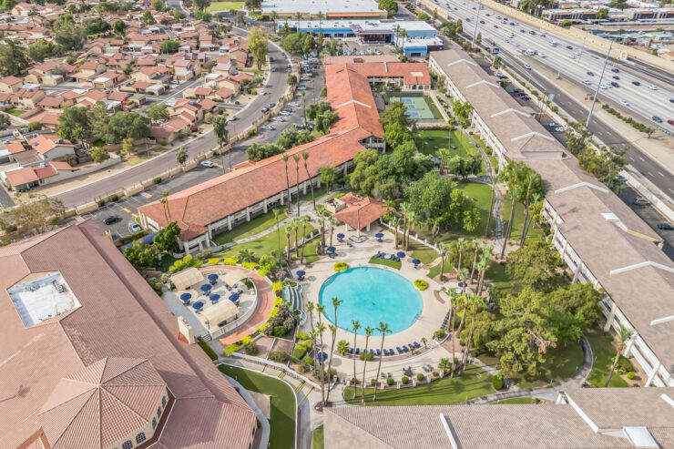 A vibrant community setting with a serene pool surrounded by lush greenery, inviting relaxation and connection.